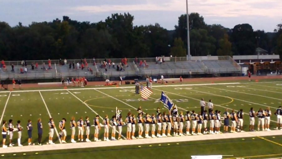 Members of the football team stand in attention as the national anthem is played. Photo by Tatiana Nevarez