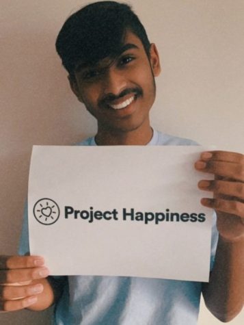 Sophomore Krishna Chinnasamy holds up a Project Happiness logo. Photo courtesy of Chinnasamy