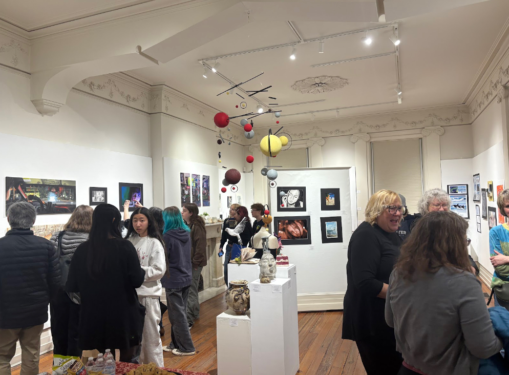 Guests observe students’ artwork. 