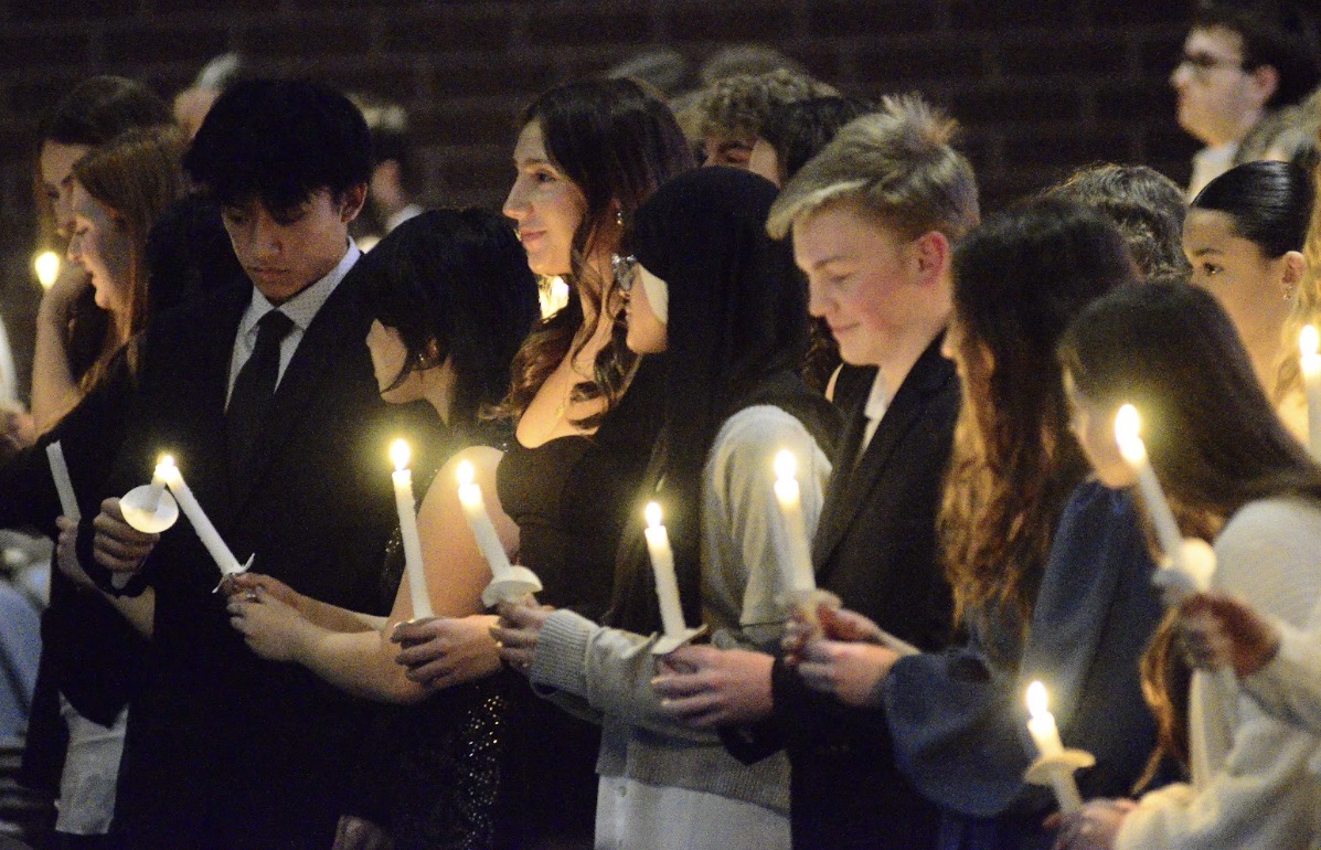 (National Honor Society inductees passing the flame. Photo courtesy of Mrs. Schiffhauer).
