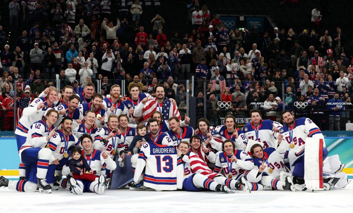Milano Cortina 2026 Olympics - Ice Hockey - Men's Victory Ceremony - Milano Santagiulia Ice Hockey Arena, Milan, Italy - February 22, 2026. Gold medalists United States hold up the jersey of the late John Gaudreau and celebrate with his children, Noa Harper Gaudreau and Johnny Edward Gaudreau, as they pose for a photograph and celebrate with their medals during the ceremony REUTERS/Mike Segar     TPX IMAGES OF THE DAY