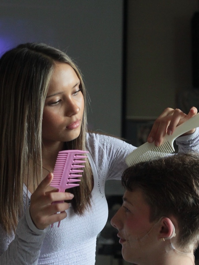 Ava Romero styles a performer’s hair. Some actors wear wigs while others get their hair styled before every performance.
